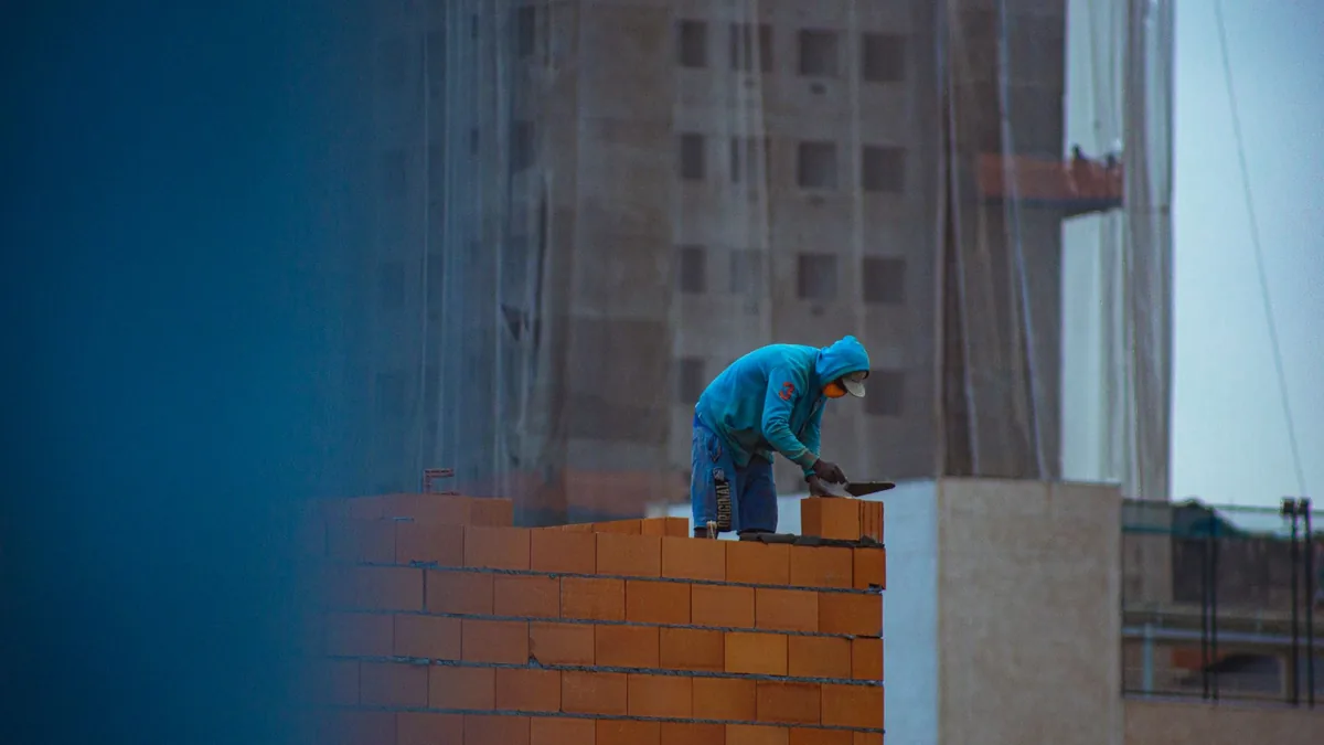 Mason finishing a reinforced block wall on a South Florida job site