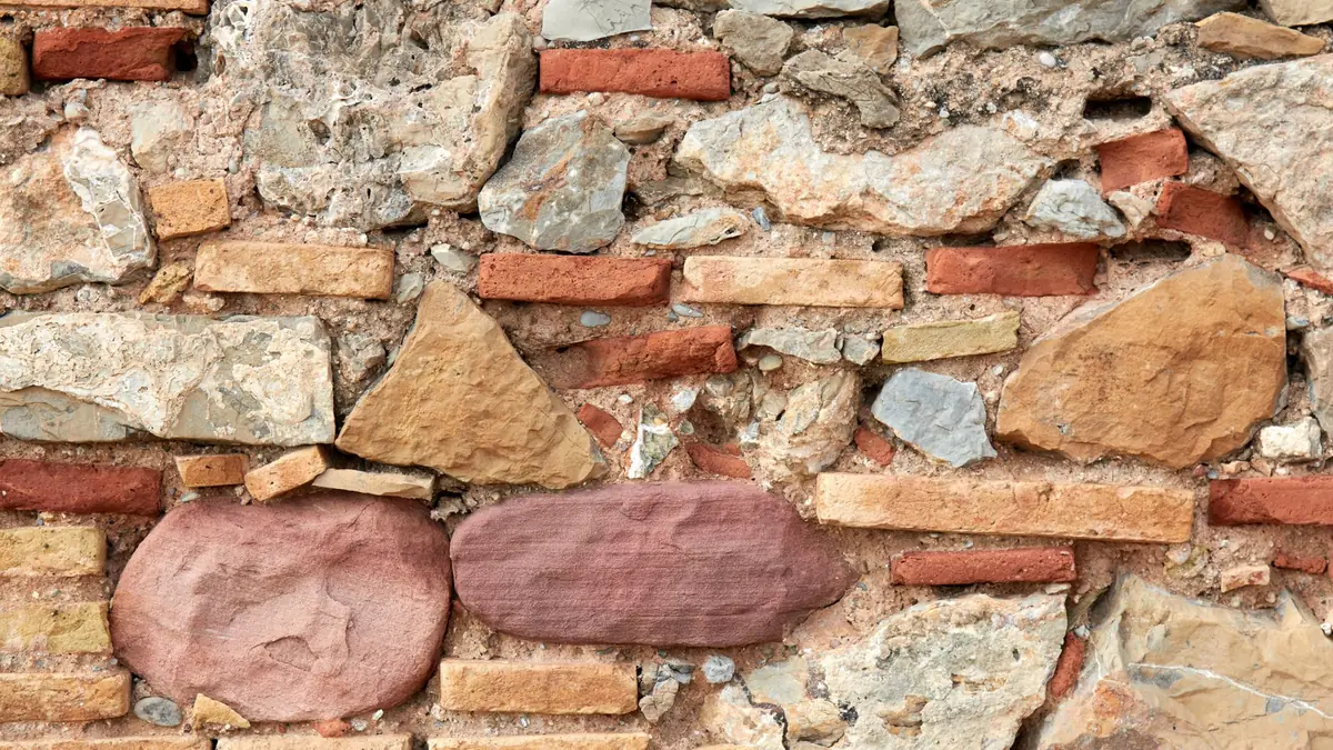 Mason repointing cracked mortar joints on a South Florida brick wall